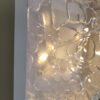 Close-up detail of hand-sculpted epoxy resin relief showing organic transparent textures.